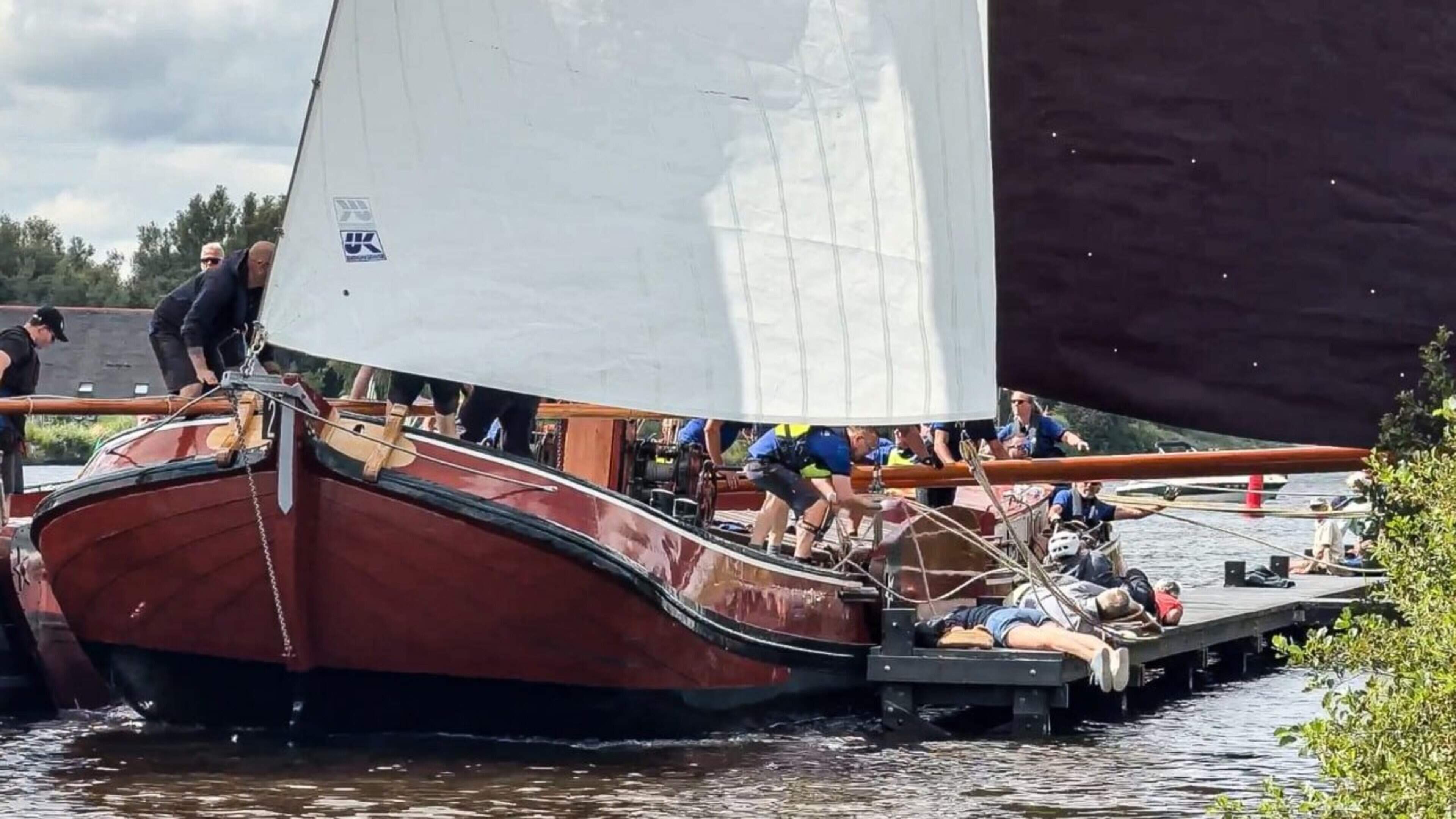 Skûtsjes botsen vlak voor finish, publiek duikt weg op steiger en bemanningslid gewond