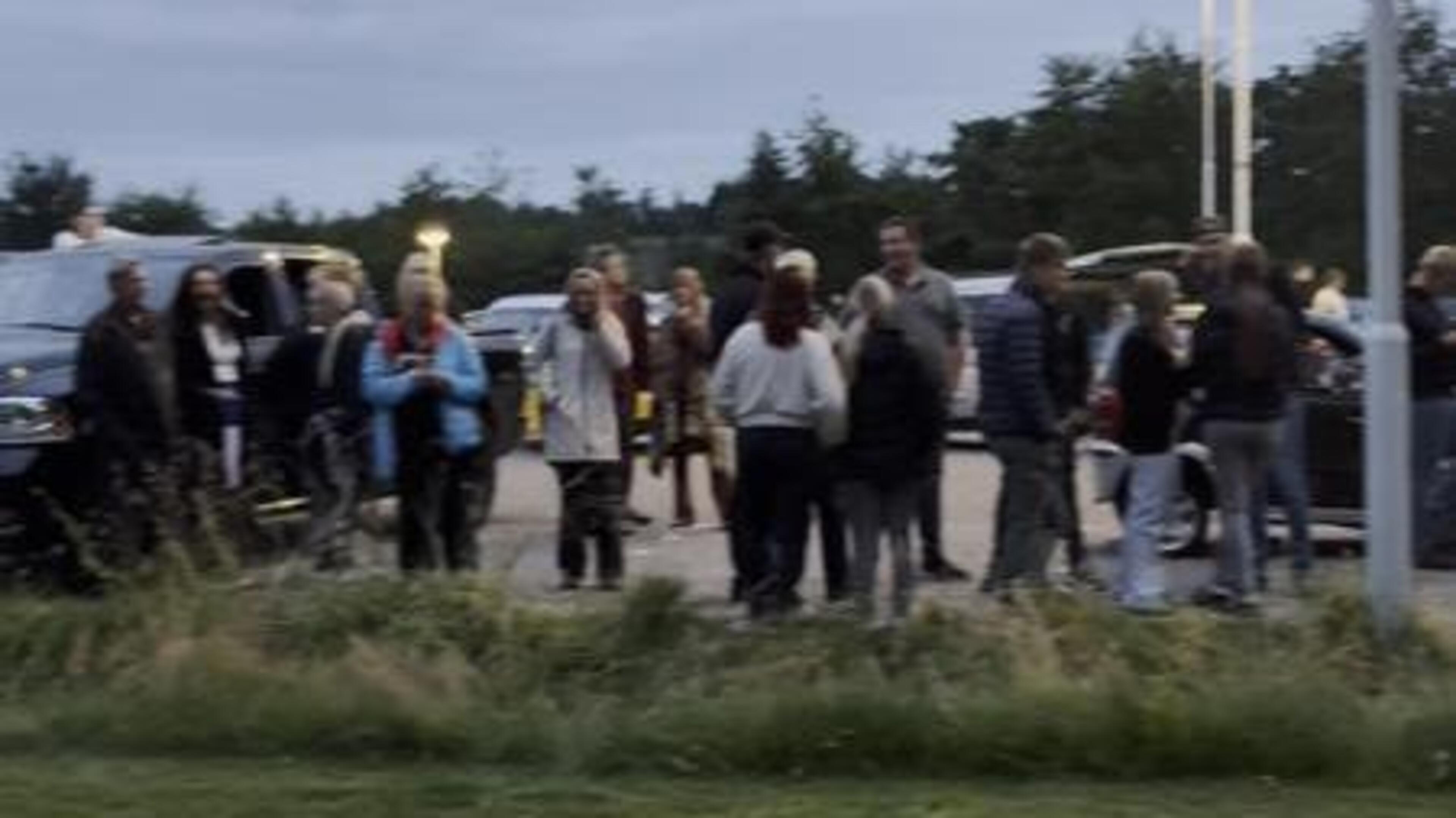 Mensen verzamelen zich bij de sporthal in Surhuisterveen.